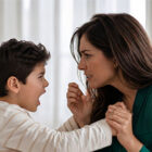 Child showing anger and emotional frustration while parent offers support